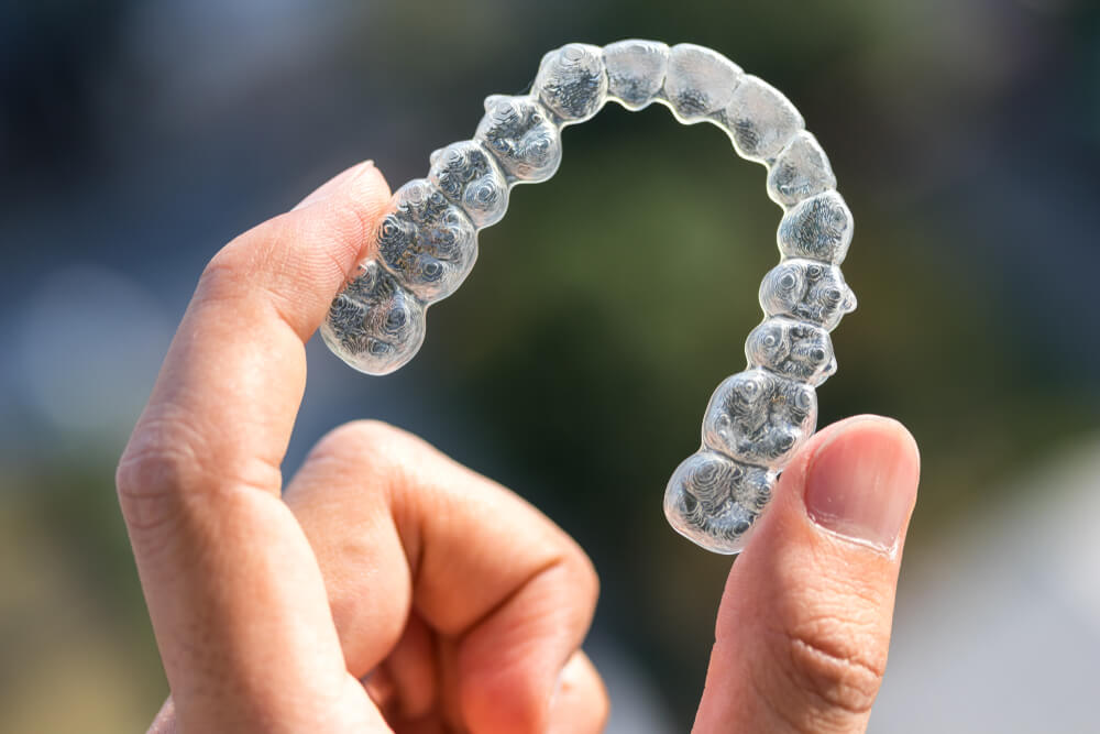 Holding Invisalign Between Fingers